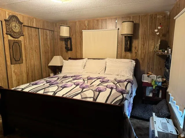 Wood-paneled room featuring a built-in closet with sliding doors, two wall-mounted sconces, and a ceiling light fixture