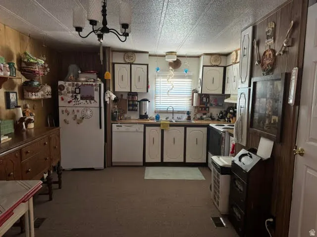 Kitchen featuring light cabinetry, wood-finish countertops, and a white refrigerator