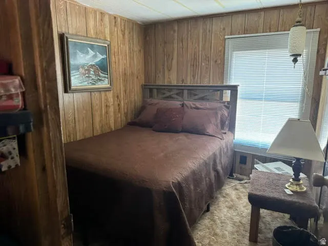 Wood-paneled room with a window featuring horizontal blinds and a built-in light fixture