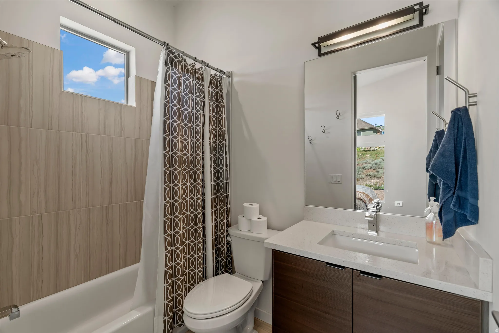 Bathroom vanity featuring a light-toned countertop with an integrated rectangular sink