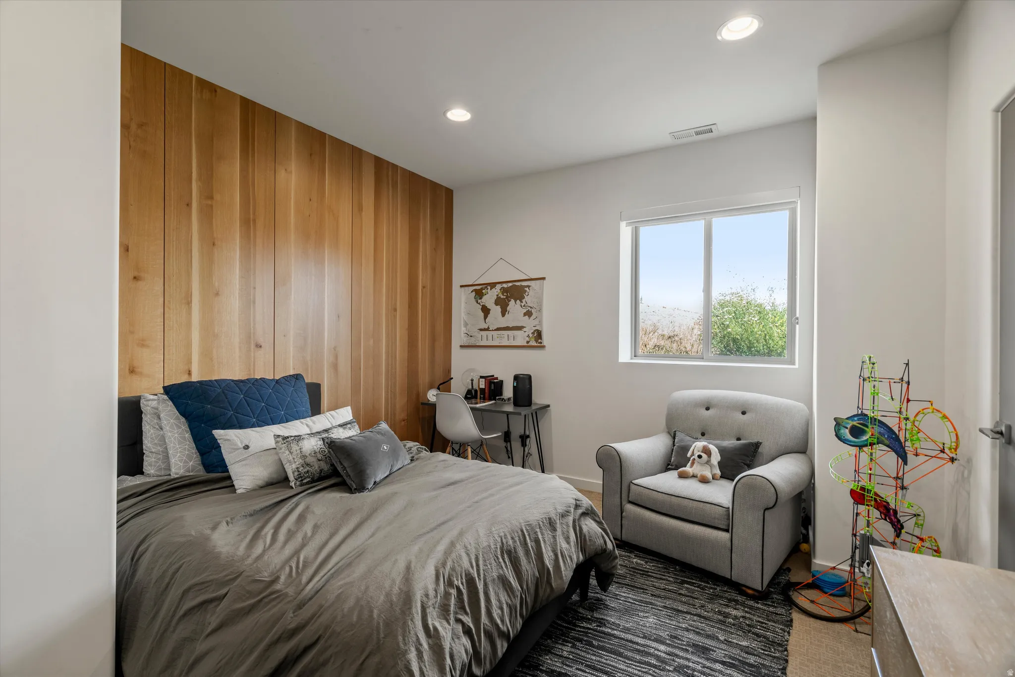 Room featuring a prominent wood-finish accent wall, recessed lighting, and a large window with white trim