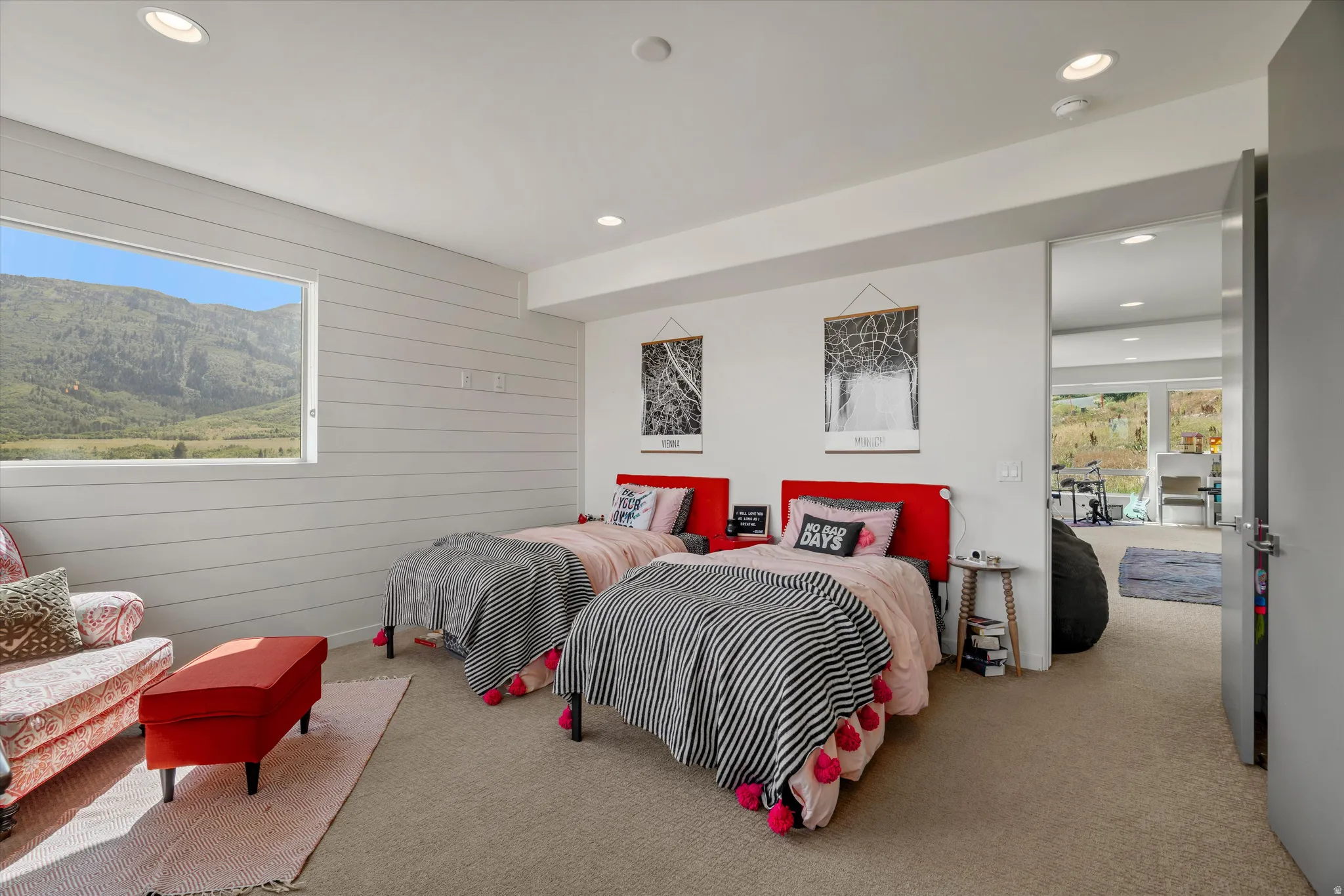 Carpeted room featuring a large horizontal window and shiplap wall paneling