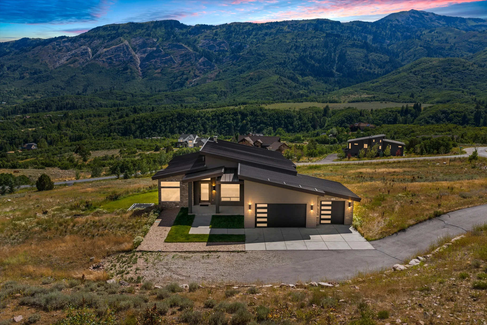 Contemporary residence featuring a striking architectural design with a dark roofline and light-toned exterior