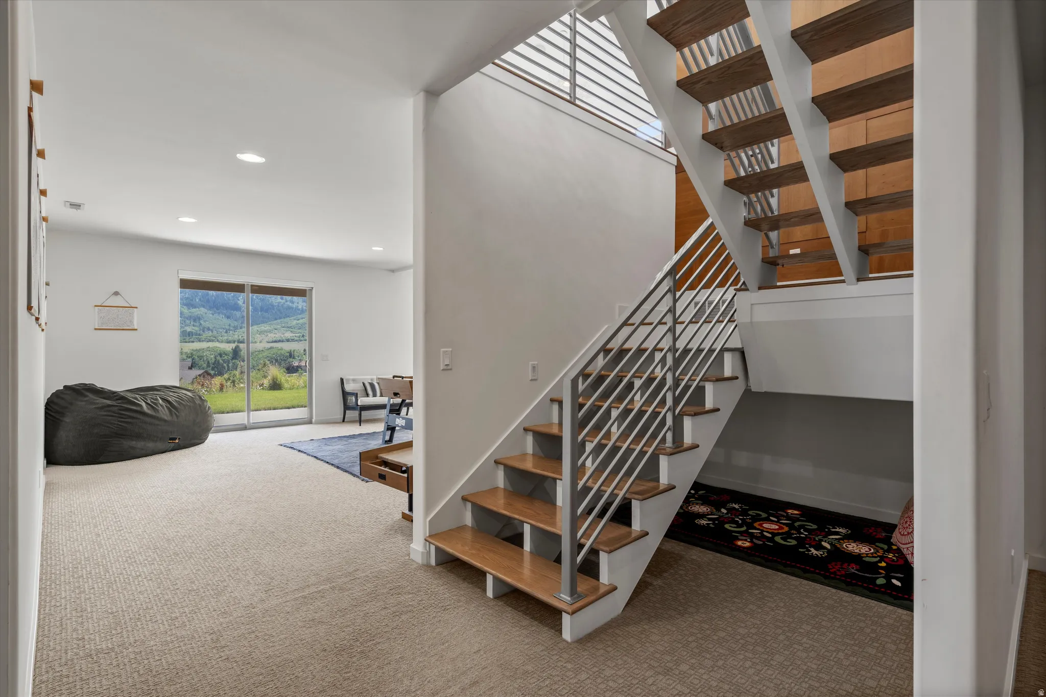 Open-riser staircase with wood-finish treads and metal railing