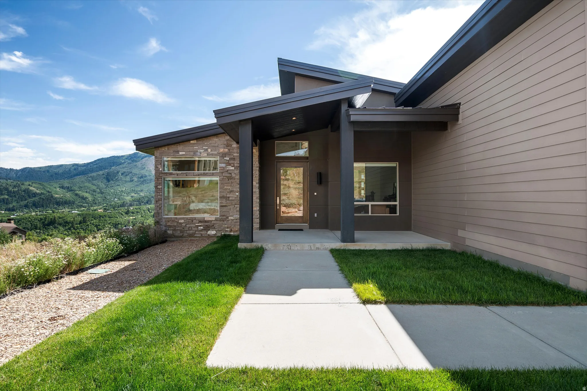 Contemporary architectural design featuring a prominent stone facade and horizontal siding