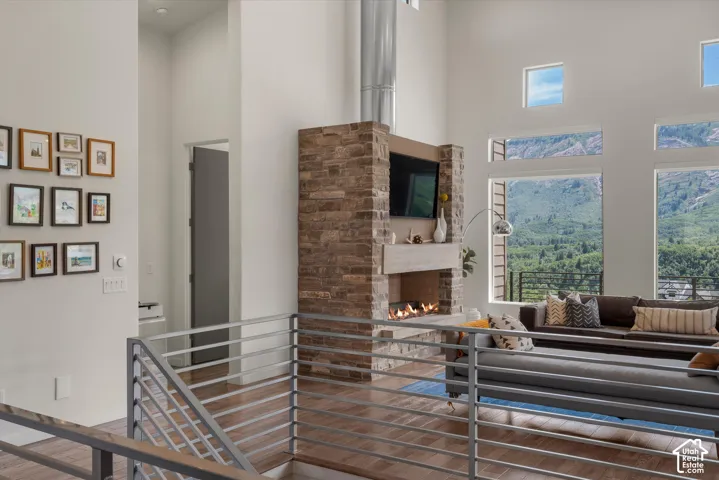 Spacious living area featuring high ceilings, a stone-clad fireplace, and extensive window walls