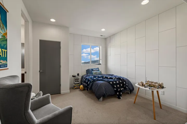 Recessed lighting illuminates a space featuring a prominent window with mountain scenery