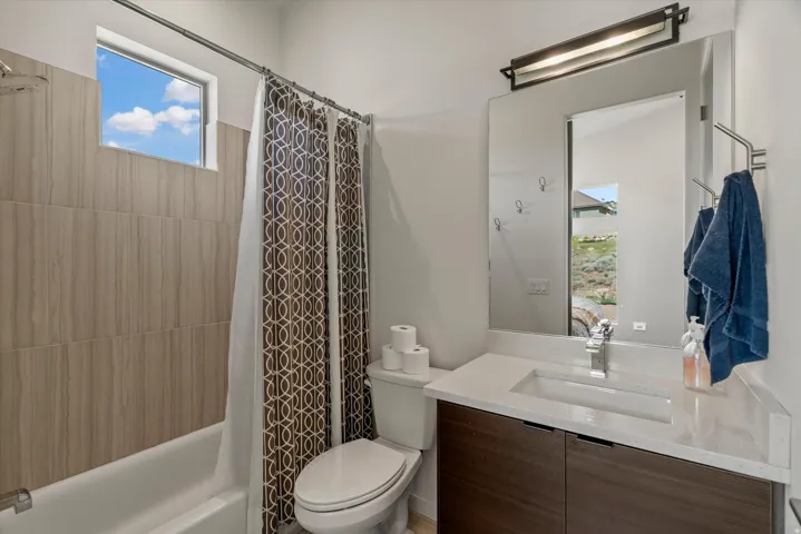 Bathroom vanity featuring a light-toned countertop with an integrated rectangular sink