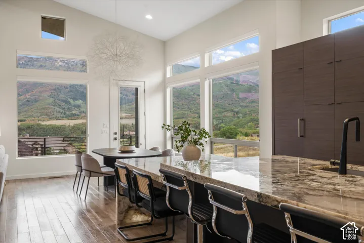 Gourmet kitchen with an expansive island featuring a polished stone countertop and integrated sink with a matte black faucet