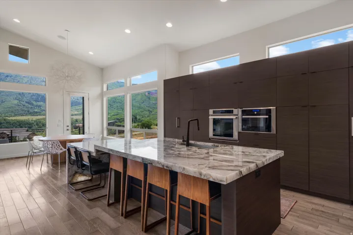 Contemporary kitchen featuring a large island with a substantial stone countertop