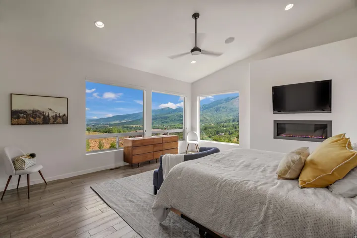 Room featuring wood-finish flooring, recessed lighting, and a vaulted ceiling with a ceiling fan