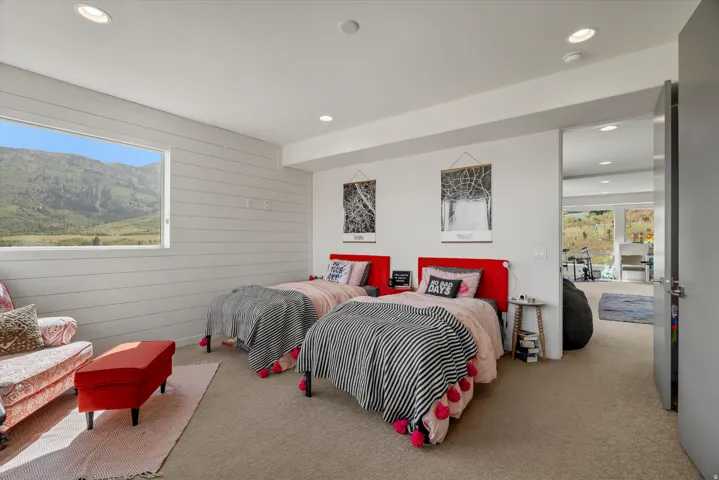 Carpeted room featuring a large horizontal window and shiplap wall paneling