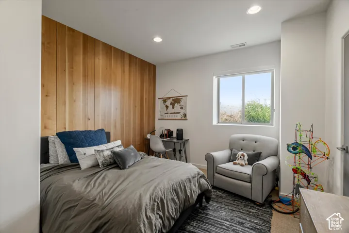 Room featuring a prominent wood-finish accent wall, recessed lighting, and a large window with white trim