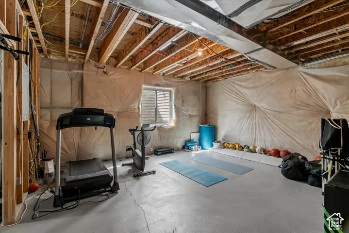 Unfinished basement with exposed ceiling joists and concrete flooring