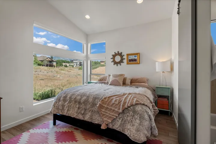 Room featuring wood-finish flooring, recessed lighting, and a high vaulted ceiling