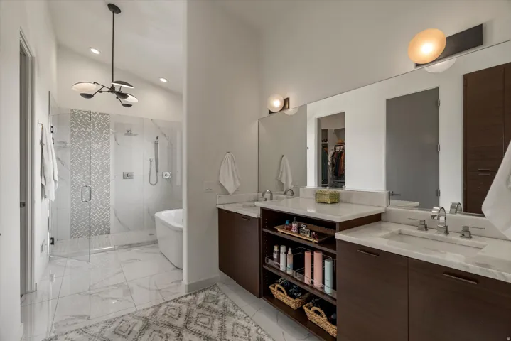 Dual vanity featuring wood-finish cabinetry, white countertops, and undermount sinks