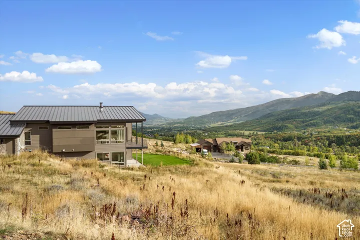 Modern exterior featuring a metal roof, expansive windows, and an outdoor balcony