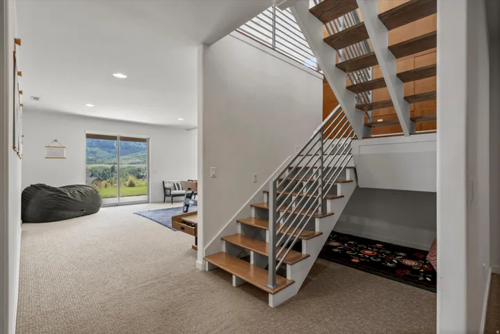 Open-riser staircase with wood-finish treads and metal railing