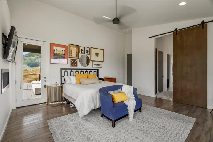 Spacious room featuring wood-finish flooring, a contemporary ceiling fan, and recessed lighting