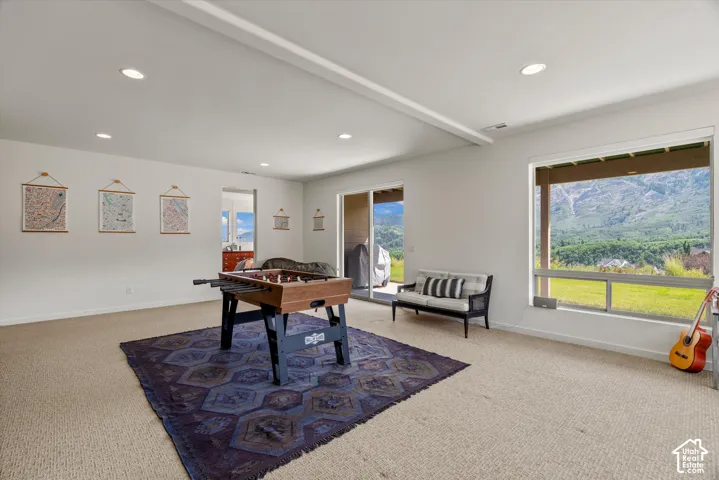 Expansive recreation room featuring recessed lighting, a sliding glass door, and a large window presenting mountainous scenery