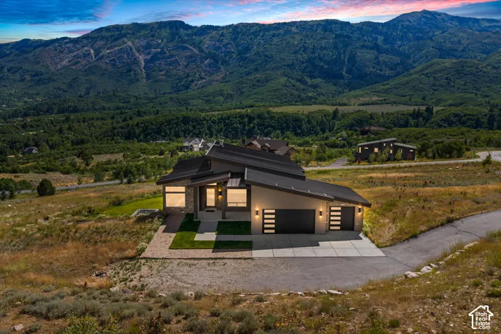 Contemporary residence featuring a striking architectural design with a dark roofline and light-toned exterior