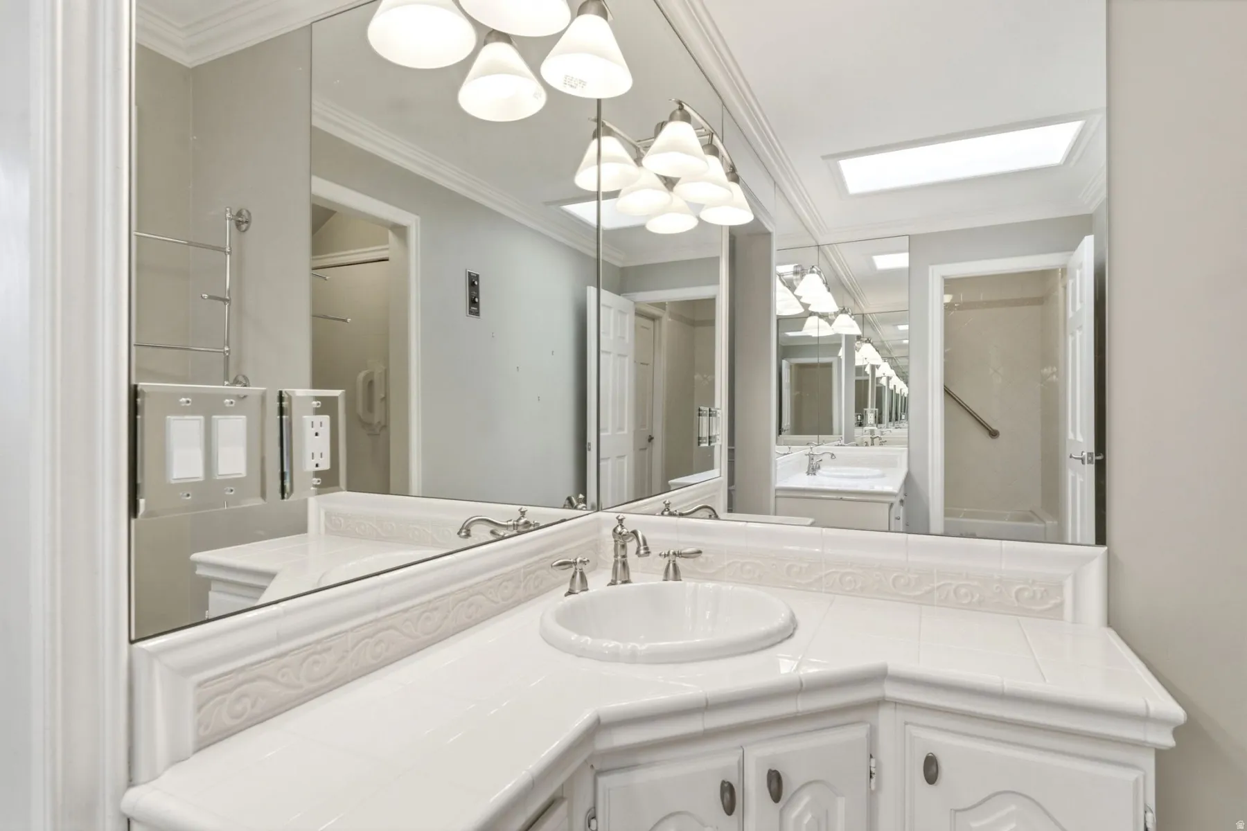 Corner vanity with an integrated sink, tile countertop, and decorative tile backsplash
