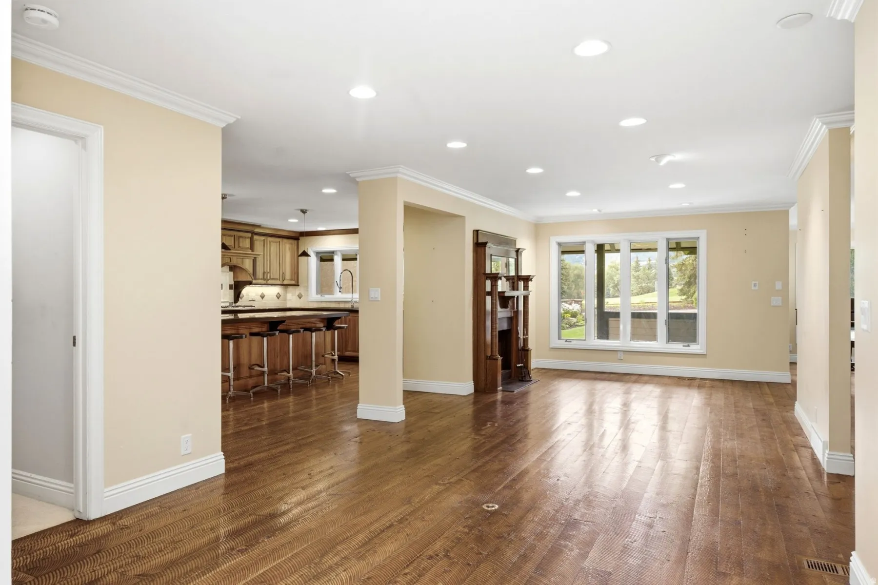 Hardwood-finish flooring, recessed lighting, crown molding, and a built-in wooden mantel