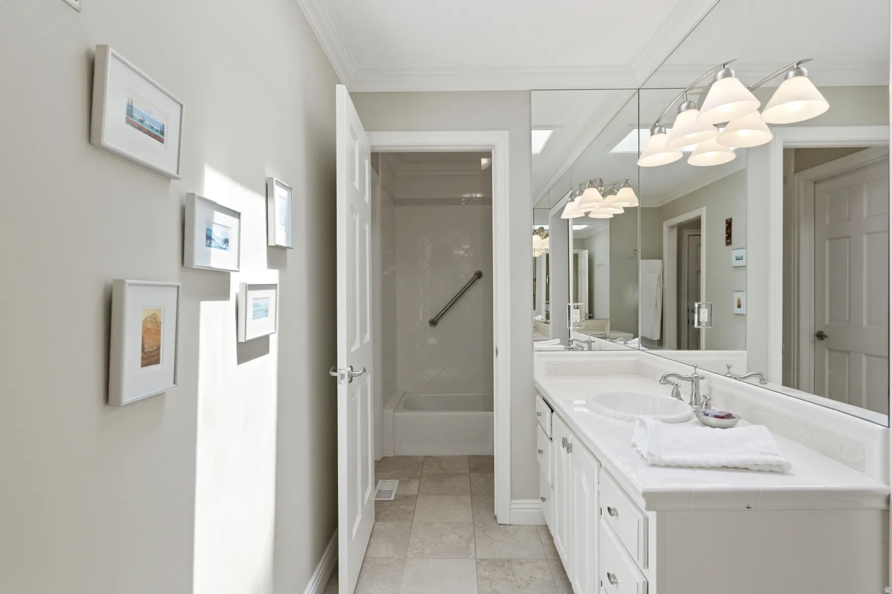Dual vanity with integrated sinks, expansive mirror, and overhead lighting