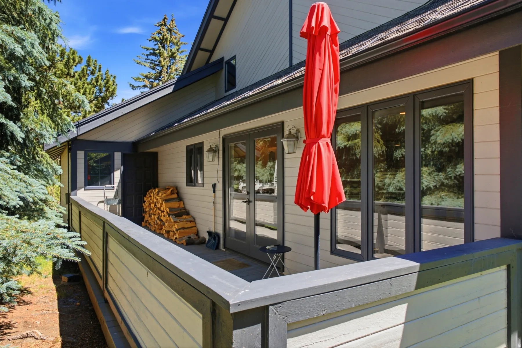 Exterior balcony featuring durable siding, multiple window panels, and a wood-slat railing