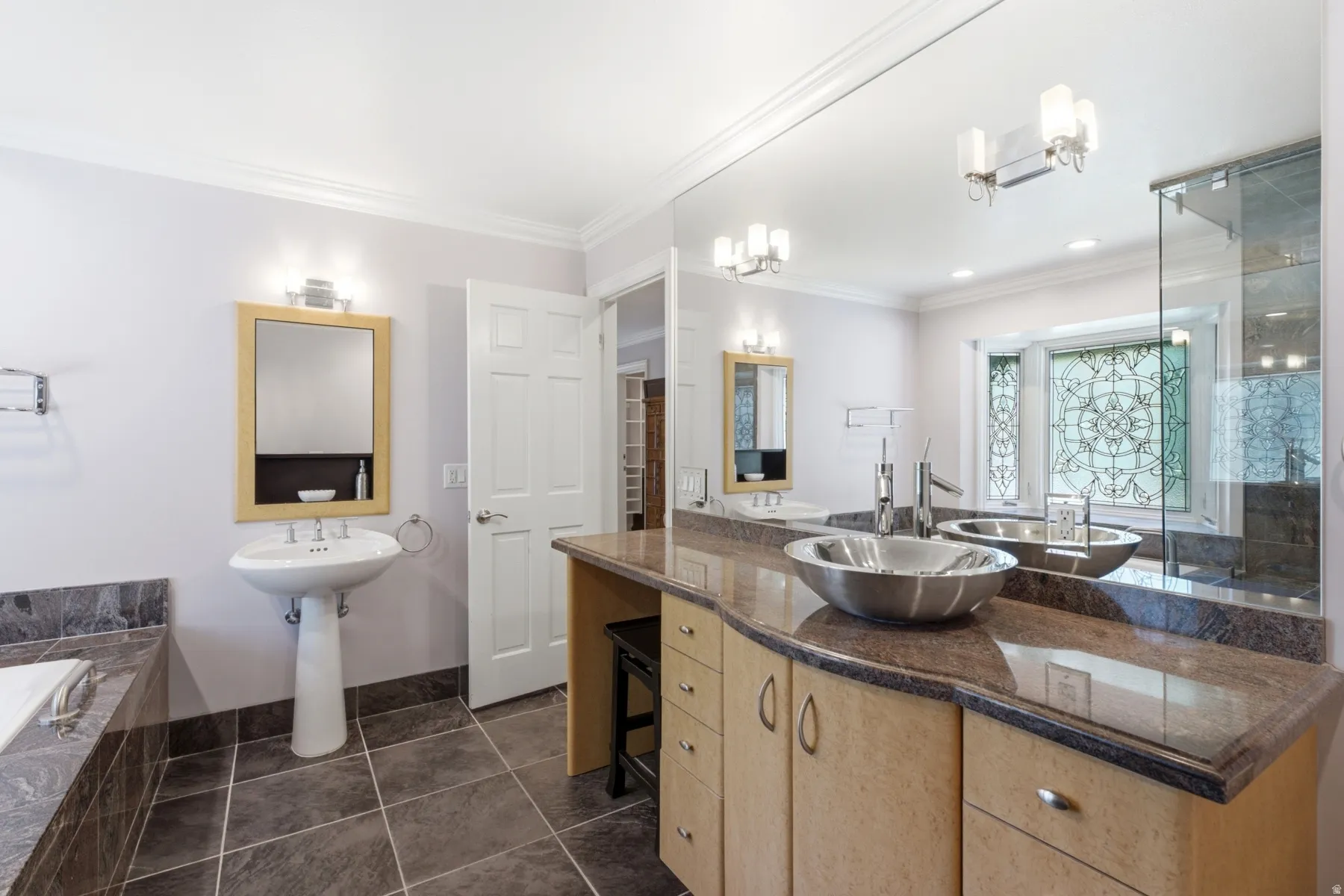 Pedestal sink, large vanity with integrated cabinetry, vessel sink, full-width wall mirror, and tiled flooring