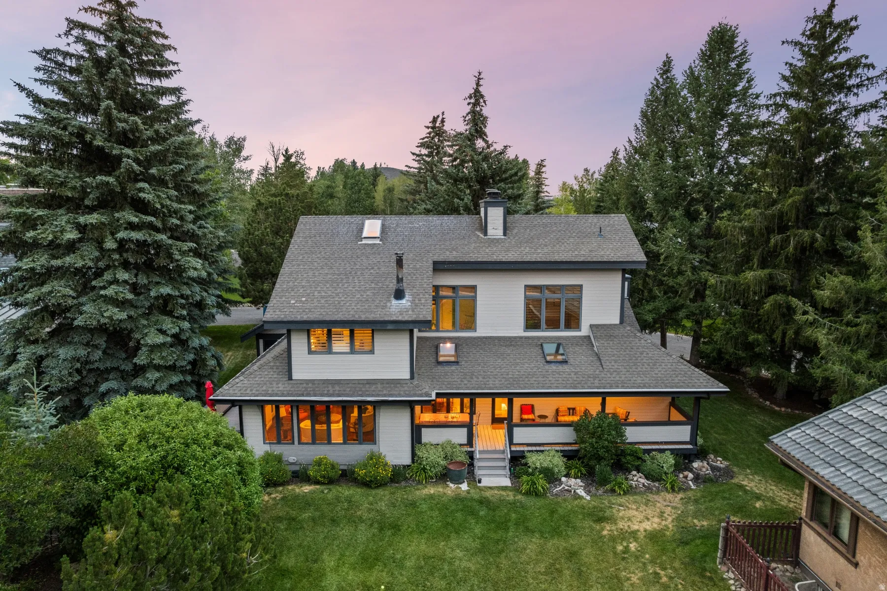 Multi-level residence featuring a covered patio, multiple skylights, and a detached structure