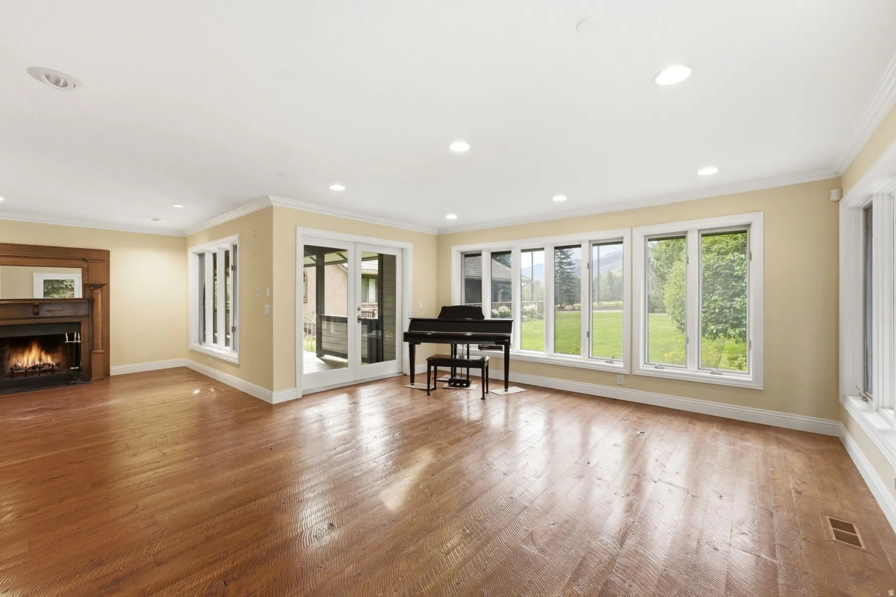 Hardwood flooring, recessed lighting, and a fireplace with a wood mantel