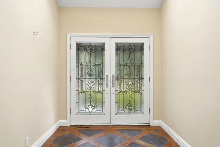 Entryway featuring decorative glass double doors and patterned floor tiling