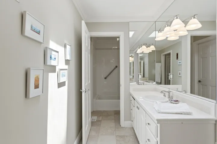 Dual vanity with integrated sinks, expansive mirror, and overhead lighting
