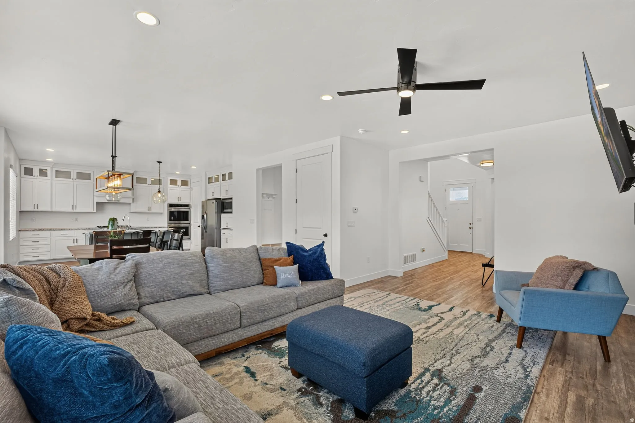 Open-concept living area with wood-finish flooring and recessed lighting