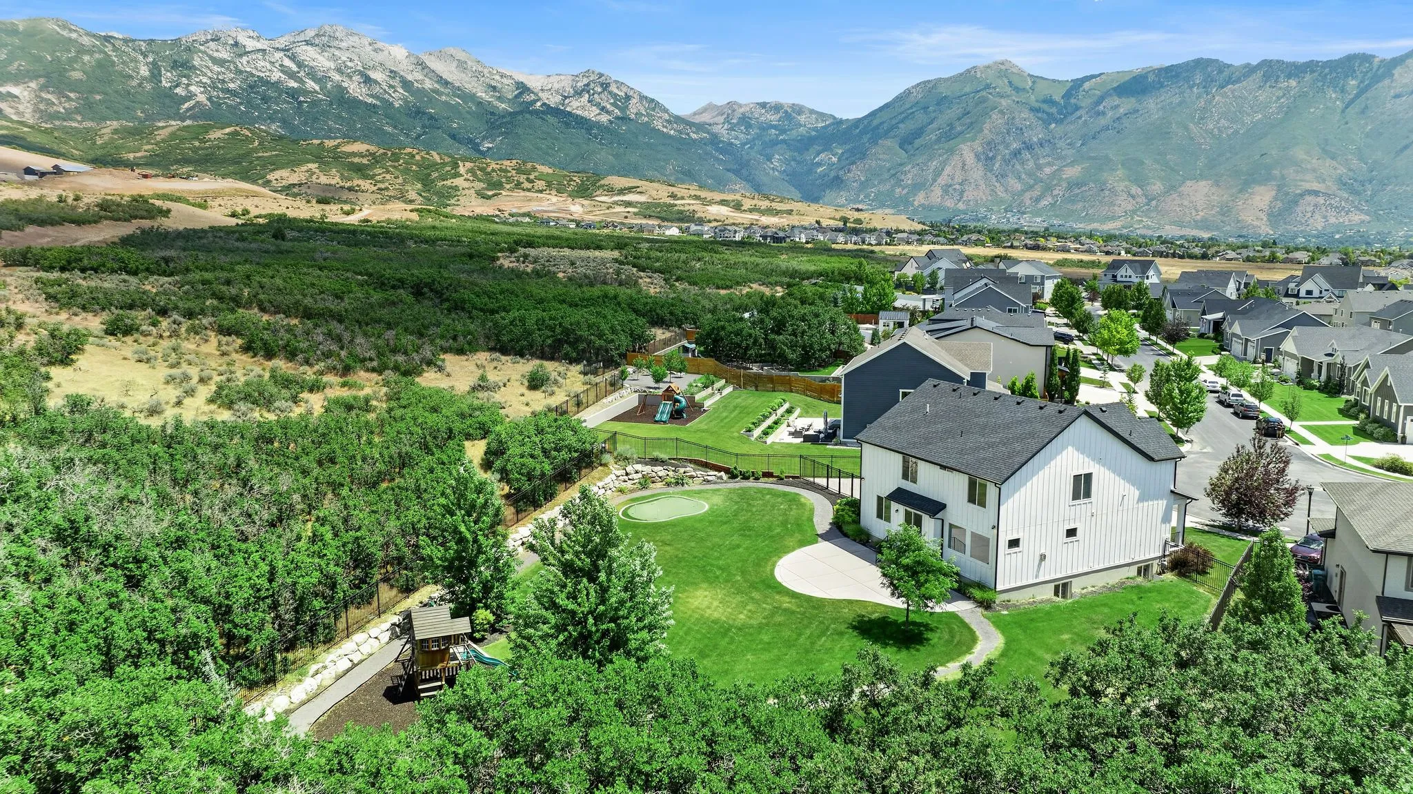 Expansive property featuring a large manicured lawn and a stone patio