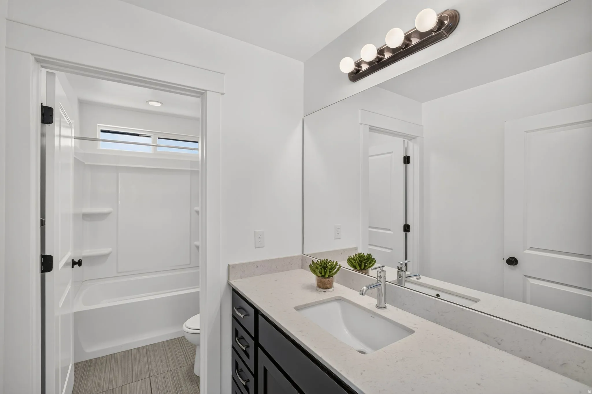 Bathroom featuring a dark wood-finish vanity with a light countertop and integrated sink
