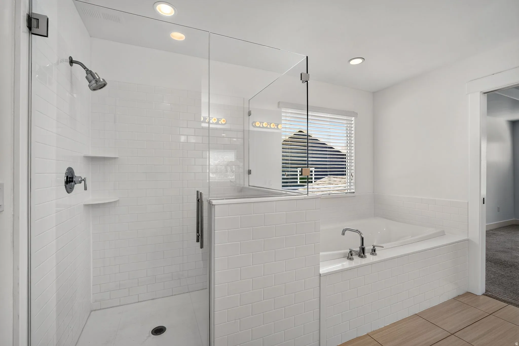 Contemporary bathroom featuring a spacious glass-enclosed shower with subway tile, a built-in soaking tub with chrome fixtures, and recessed lighting