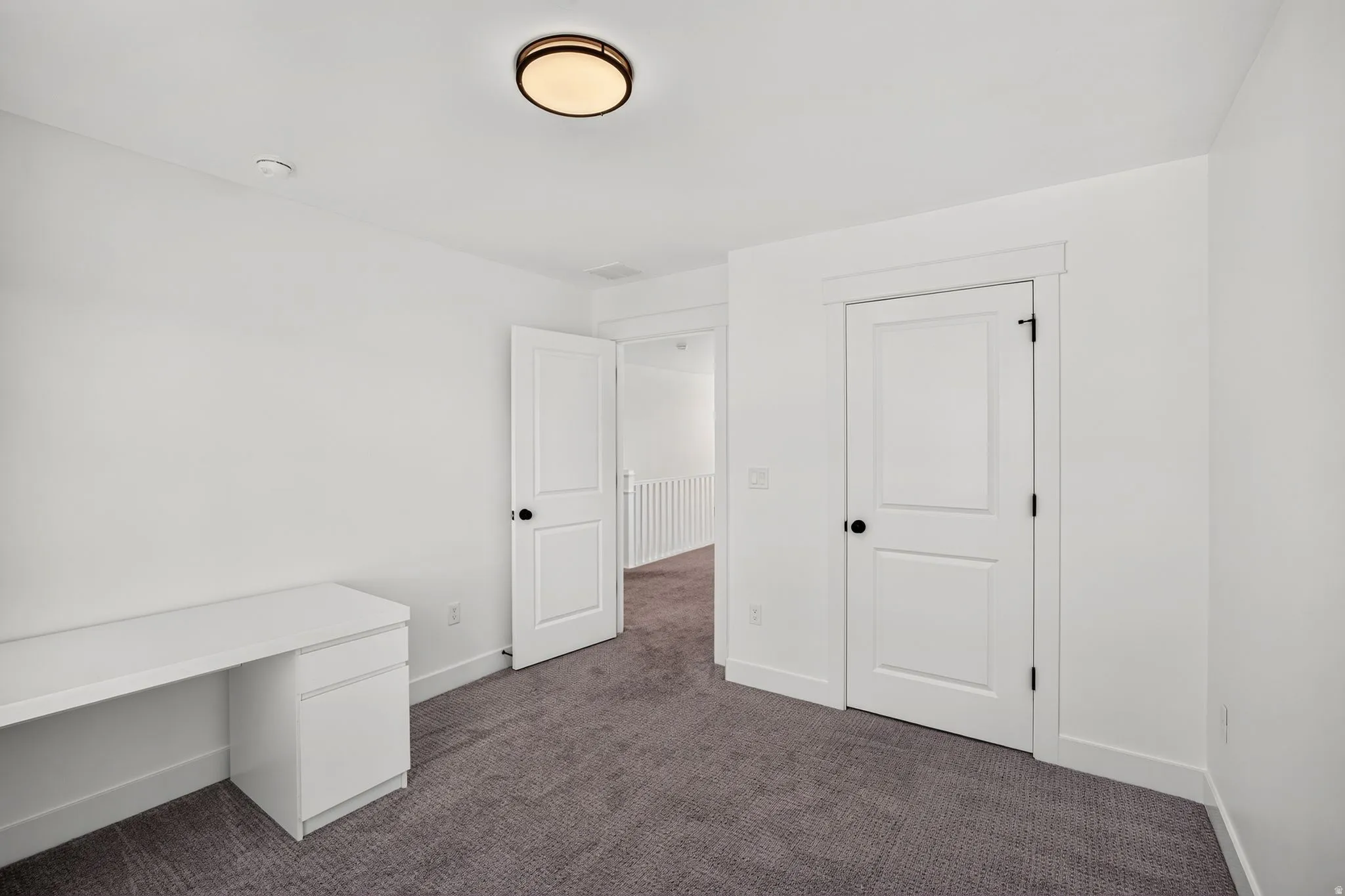 Room featuring textured grey carpeting and white walls