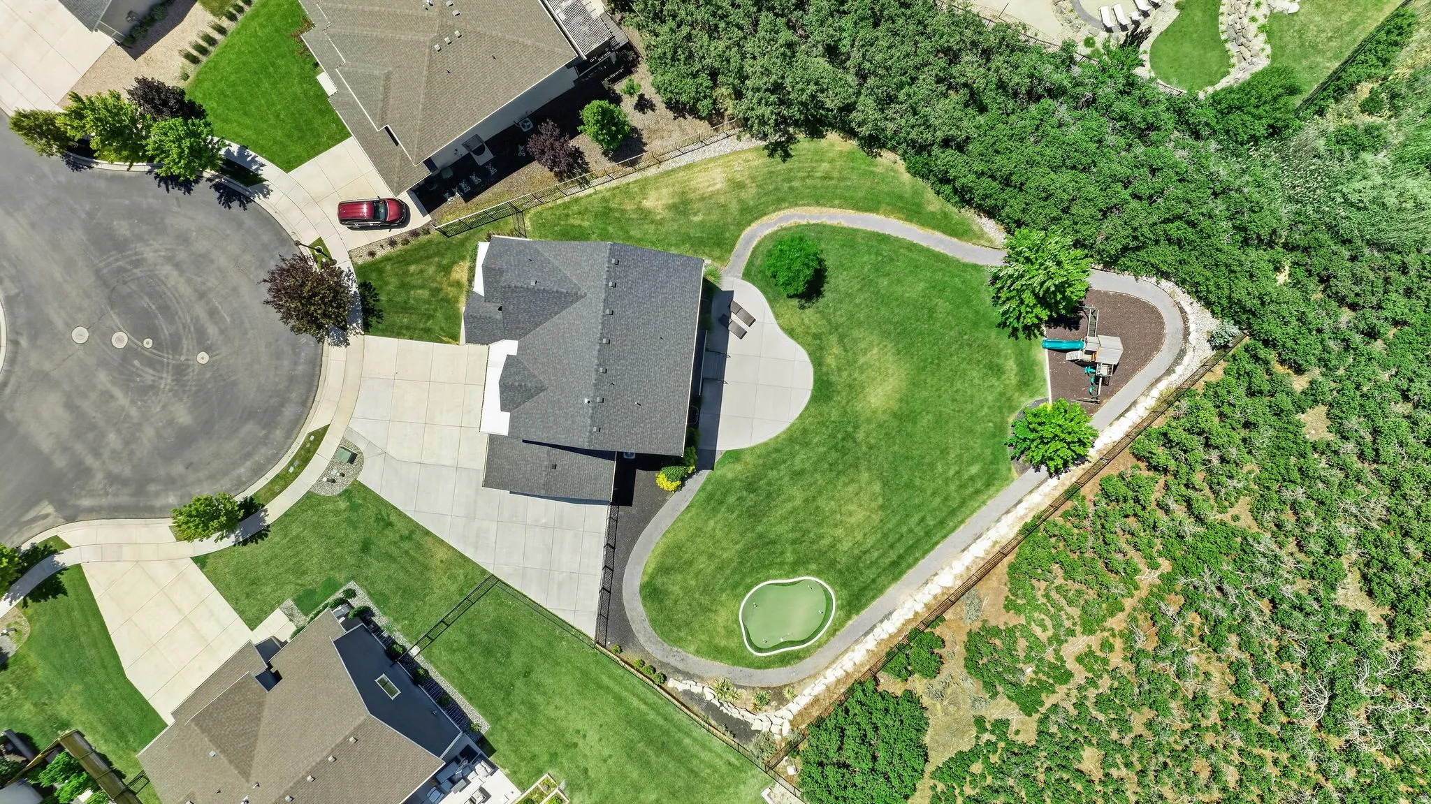 Expansive property featuring a large lawn, integrated putting green, and a winding pathway