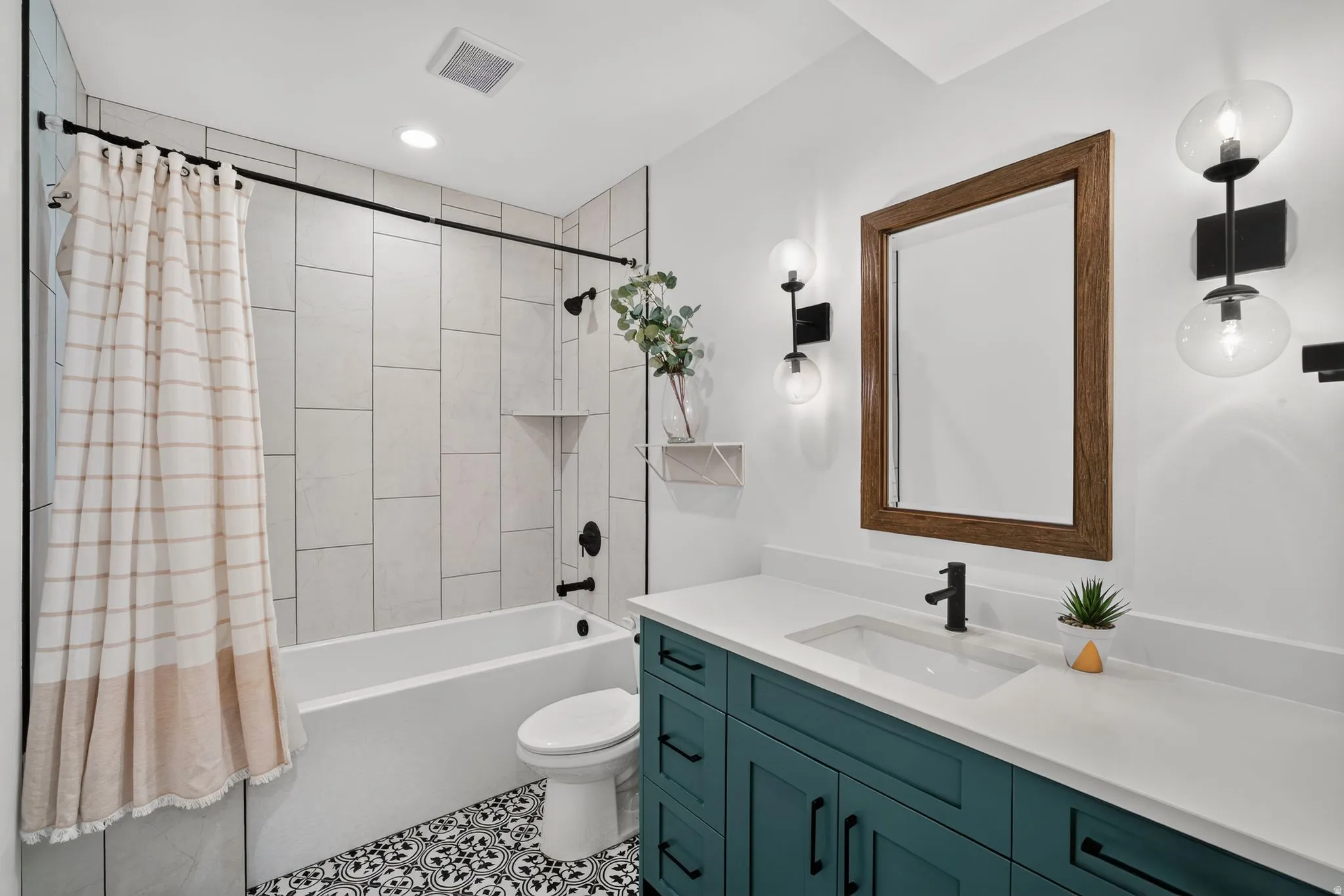 Bathroom featuring a teal double vanity with a white countertop and undermount sinks
