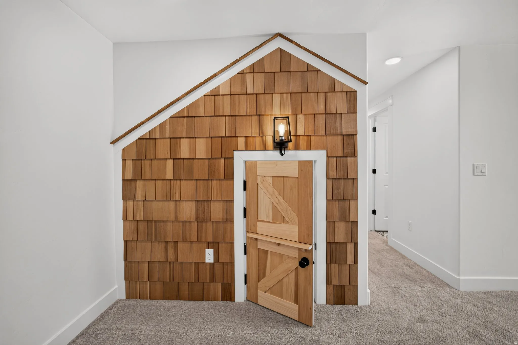 Decorative cedar shake wall with a pitched roofline accent