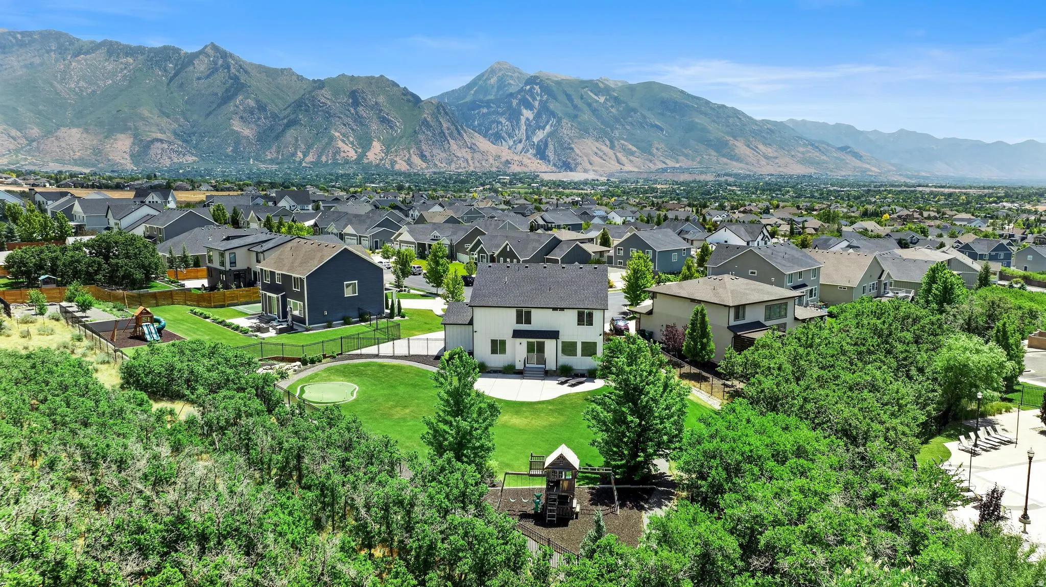 Expansive aerial view showcasing a residential neighborhood with distant mountain ranges