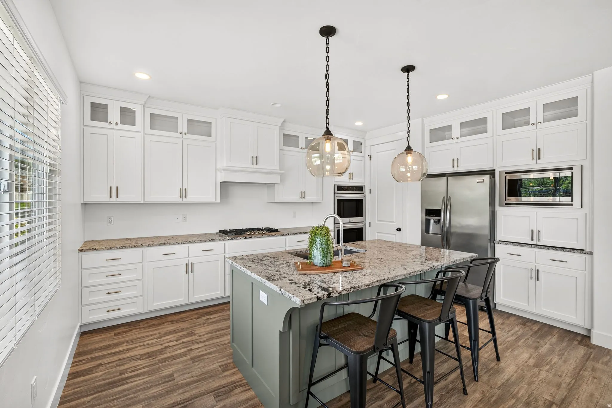 Kitchen featuring white shaker cabinetry, stainless steel appliances, and a central island with a granite countertop