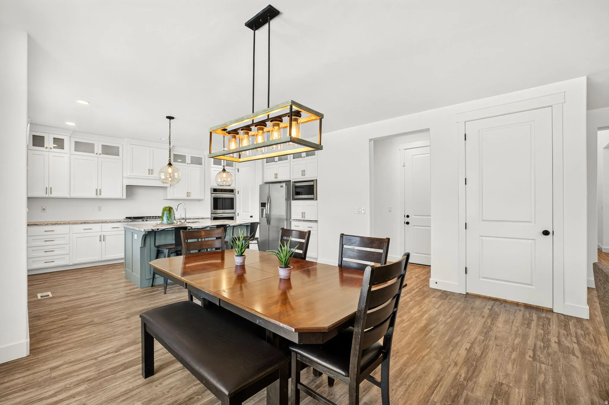 Open-concept kitchen and dining area featuring wood-finish flooring
