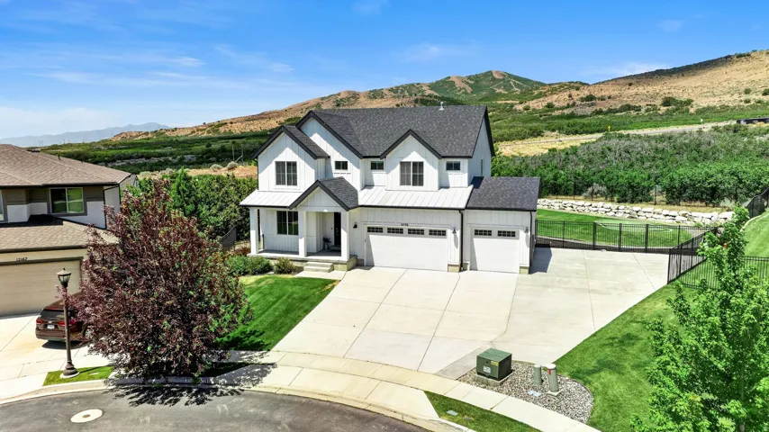 Modern farmhouse-style residence featuring a prominent white exterior with black trim accents and a contrasting dark shingle roof