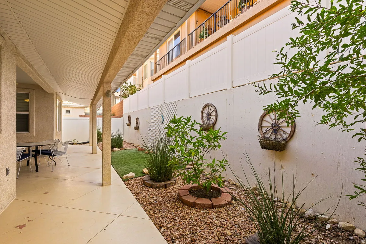 Covered patio with concrete flooring, stucco exterior, and slatted ceiling