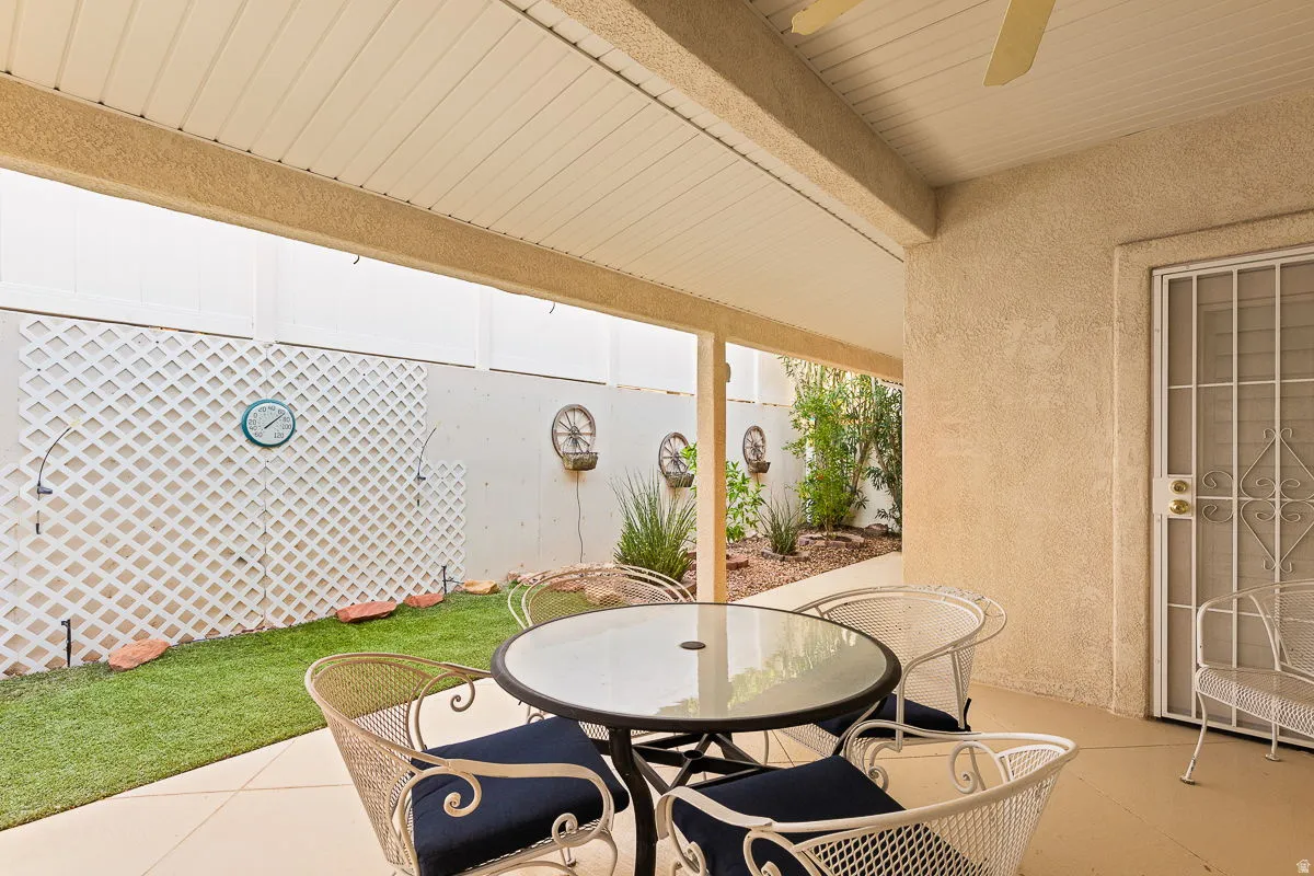 Covered patio with textured concrete flooring, a stucco exterior, and a security screen door