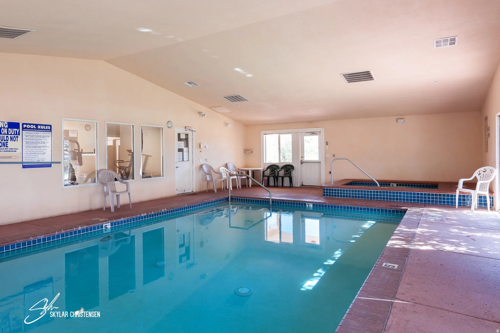 Indoor swimming pool with blue tile coping and a surrounding concrete deck