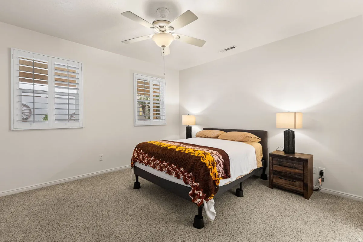 Bedroom featuring light-toned carpeting and white walls